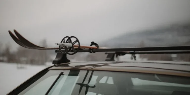 Close-up van een skidrager gemonteerd op de dwarsdragers van een auto in de sneeuw