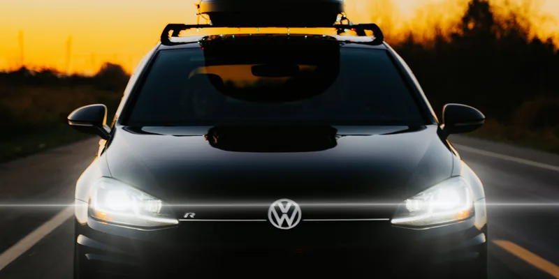Zwarte dakdragers met dakkoffer op het dak van een Volkswagen Golf