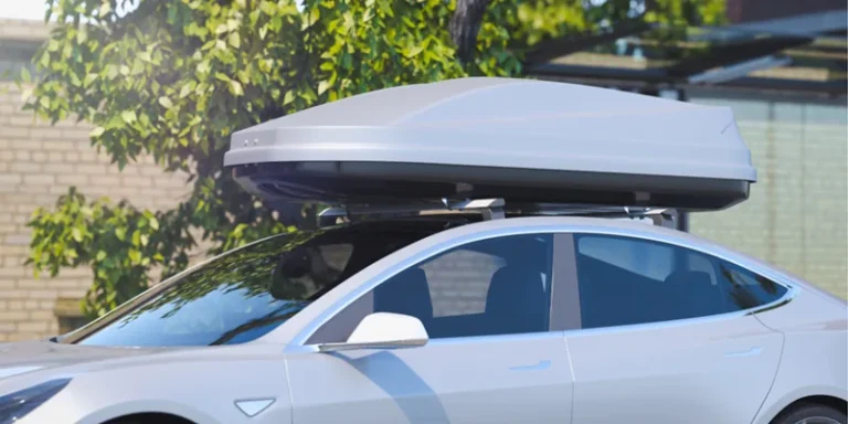 Witte Tesla met een zilvergrijze dakkoffer op de dakdragers