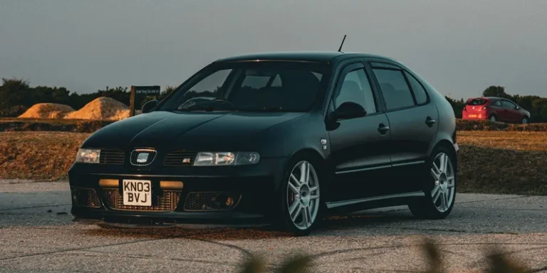 Zwarte Seat Leon geparkeerd bij zonsondergang, klaar voor dakdragers en dakkoffer