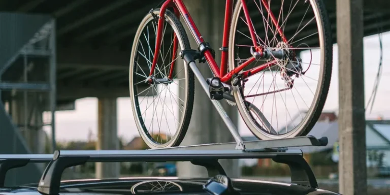 Rode fiets op een fietsdrager bevestigd aan de dwarsdragers van een auto