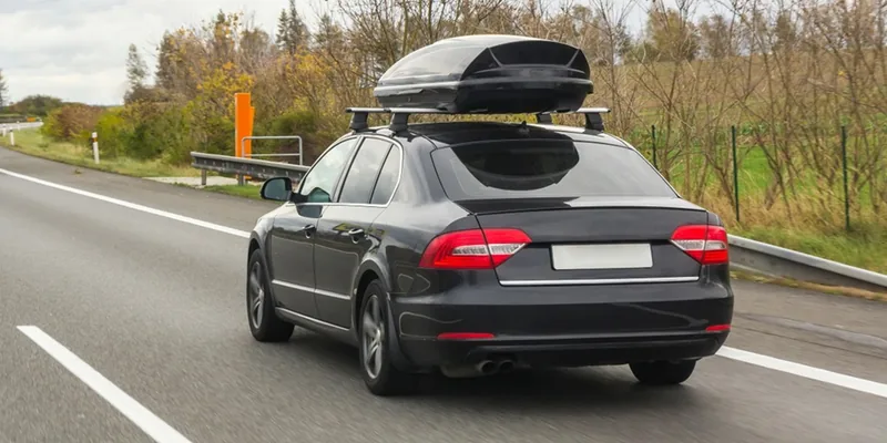 Zwarte stationwagen met dakkoffer rijdt op de snelweg