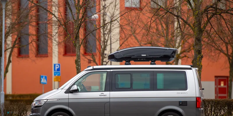Thule dakdragers met zwarte dakkoffer op het dak van een Volkswagen bus