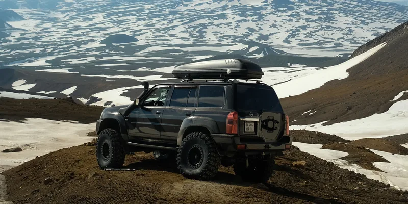 Lange smalle dakkoffer op een terreinwagen in een besneeuwd berglandschap