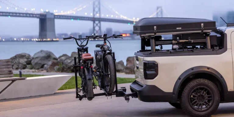 Twee fietsen op een trekhaakdrager achterop een auto aan het water