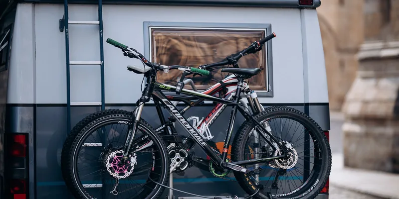 Fietsendrager met twee fietsen op de achterkant van een camper met verlichting