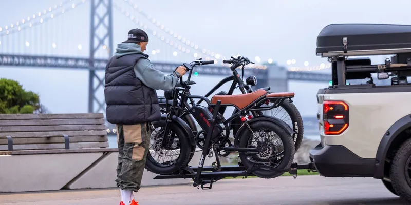 Platformdrager met twee elektrische fietsen achterop een auto